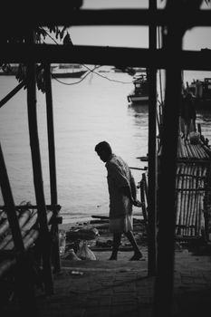 一个男人在河边沉思，这是一张黑白图像，氛围忧郁