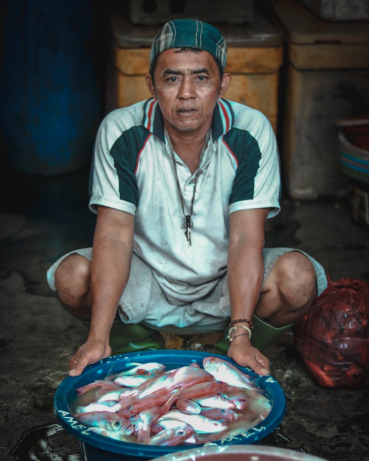 Calm Asian Man With Big Bowl Of Fresh Fish