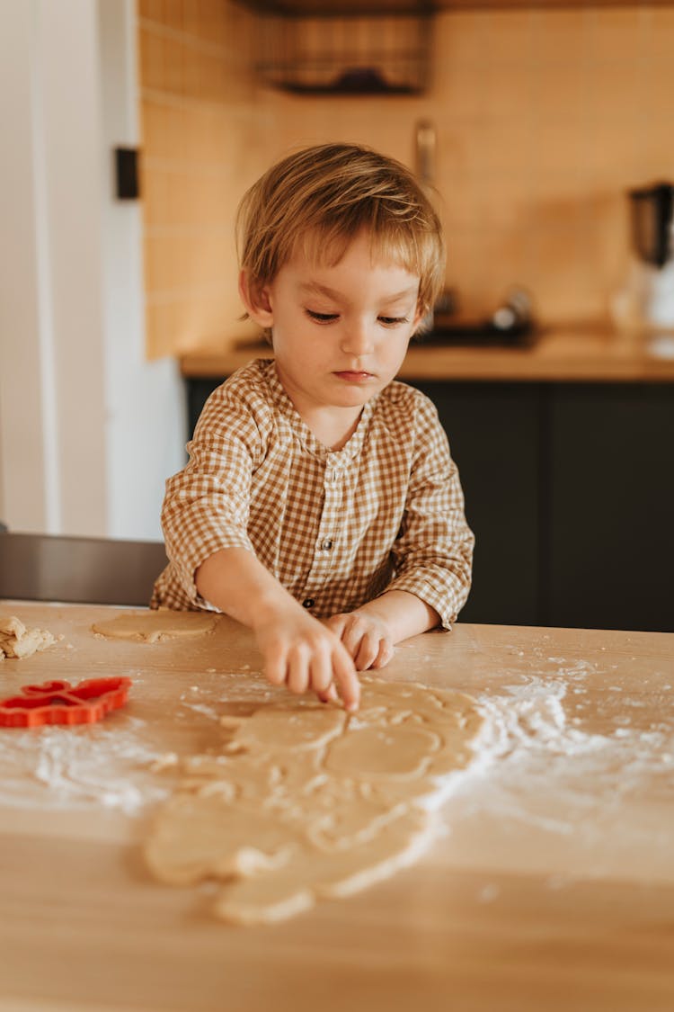 A Kid Touching A Molded Dough