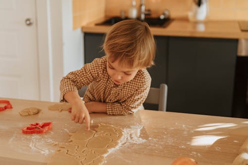 A Kid Separating Shaped Dough 