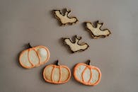 灰色背景上摆放着万圣节南瓜和蝙蝠形饼干，非常适合节日美食