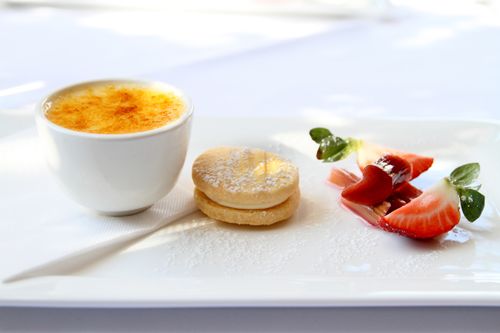 Free A beautifully plated dessert trio featuring creme brulee, a cookie, and fresh strawberries. Stock Photo