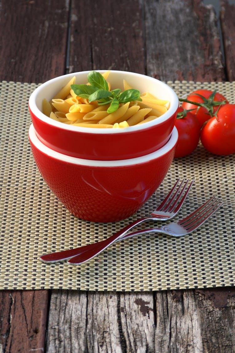 Penne Pasta Dish On Red Bowl Beside Forks