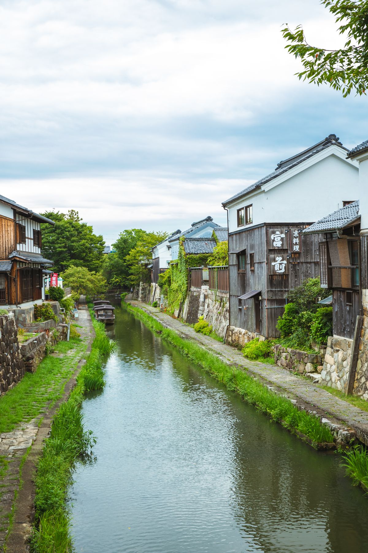 Hachiman-bori canal in Omihachiman lined with grassy banks and old white-walled merchant storehouses