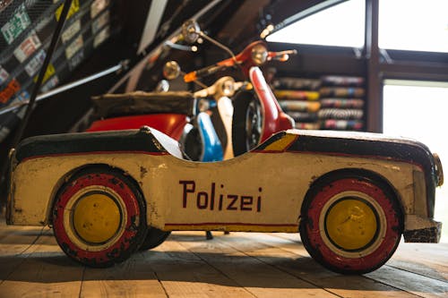 Aged toy police car on wooden shelf