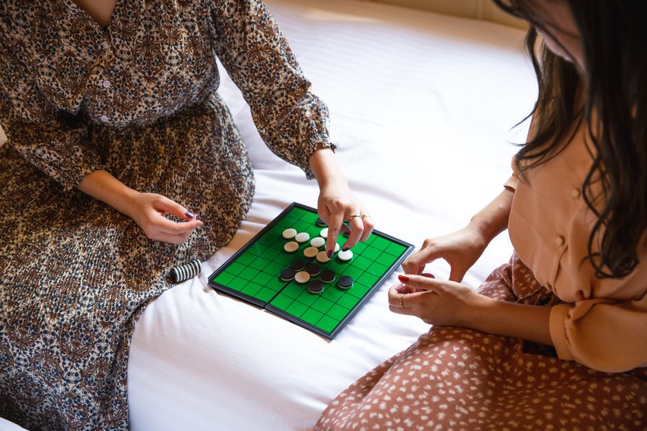 ベッドでリバーシゲームをしている認識できない女性を収穫する