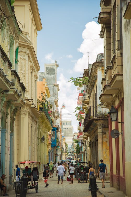 Crowded pedestrian street between old residential buildings in Havana Cuba on clear sunny weather