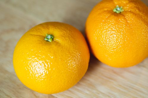 Free From above of colorful similar fresh sweet oranges with shiny peel on table in sunlight Stock Photo