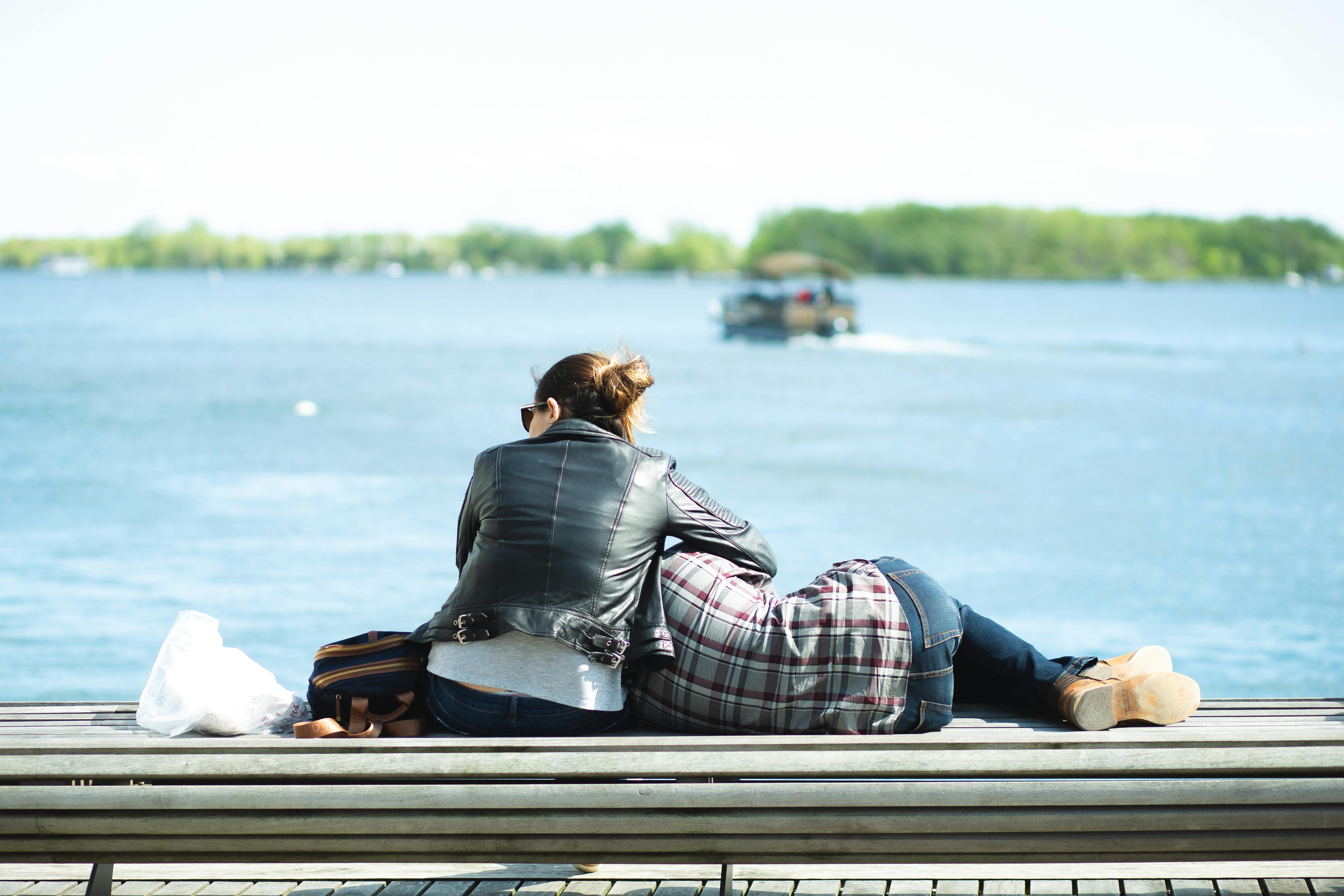 couple having rest on river embankment