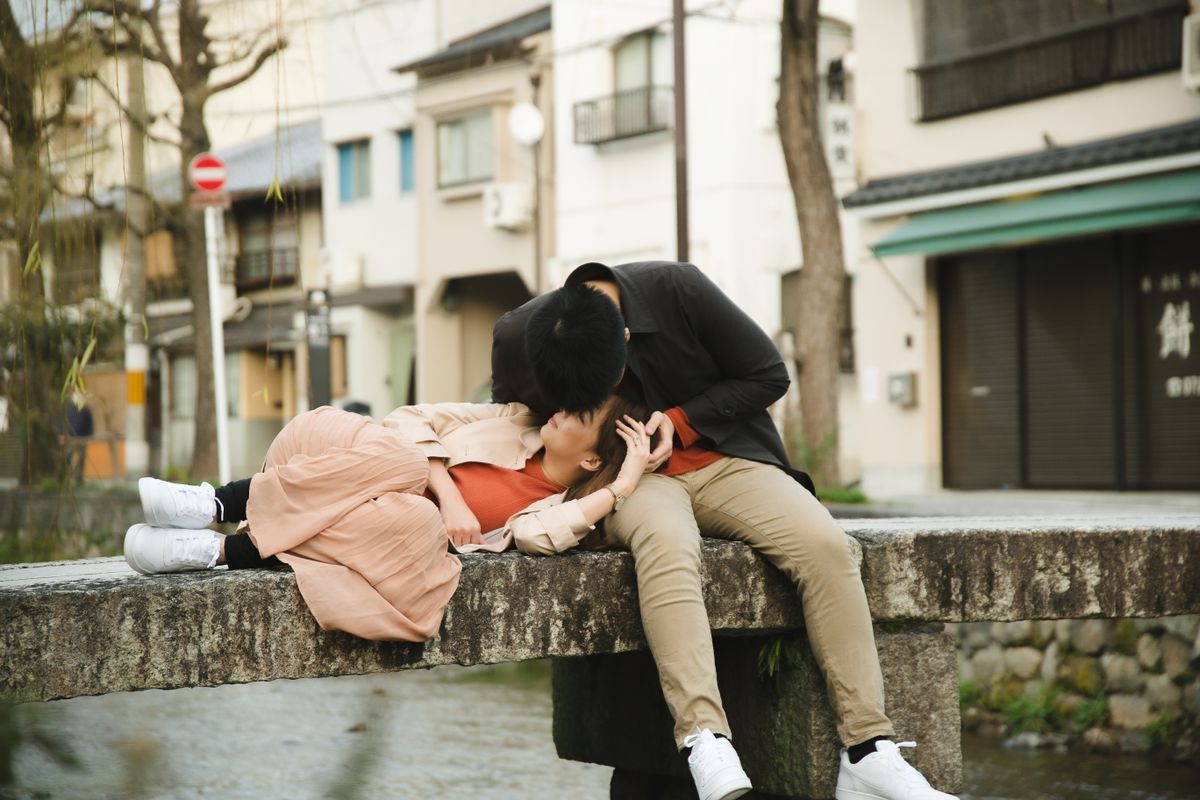 橋の上でくつろぐカジュアルな服装の夫婦の様子