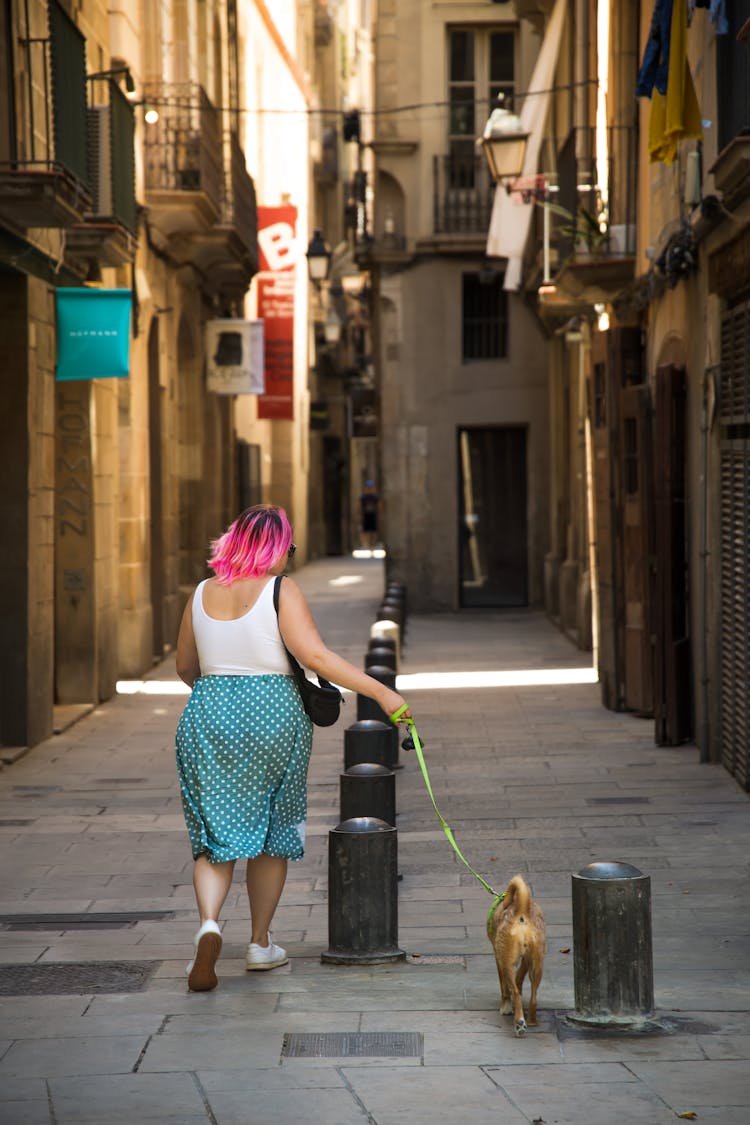 Woman With Bright Hair Walking Dog On Street