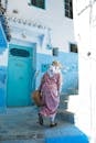 Anonymous Muslim woman walking upstairs on narrow street stairway