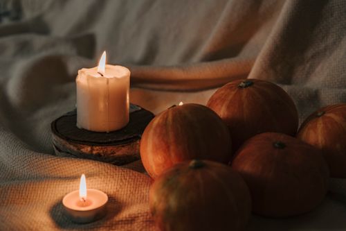 Free Warm autumn ambiance with pumpkins and candles creating a cozy, festive feel. Stock Photo