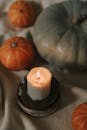 温暖的秋日场景中，点燃的蜡烛与南瓜，非常适合季节或假日主题