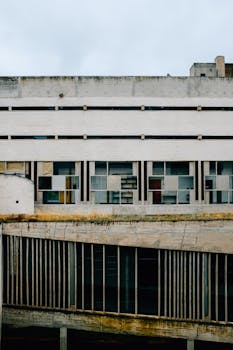 Weathered modernist building showcasing geometric design and urban decay in an outdoor setting.