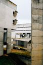Exterior of weathered concrete priory building with creative geometric shapes and square windows