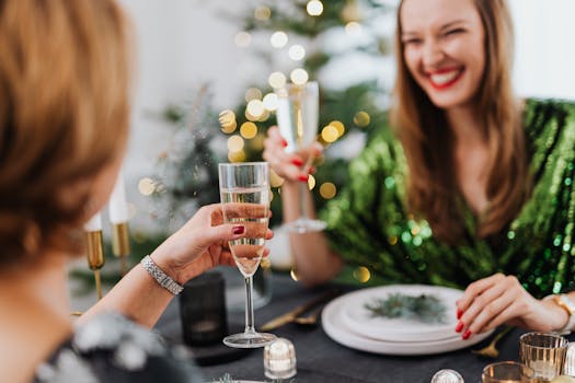 Two women enjoying a festive party indoors with champagne and laughter.