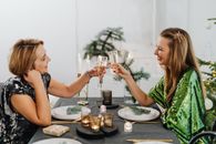 两名妇女在装饰精美的餐桌上享用节日吐司