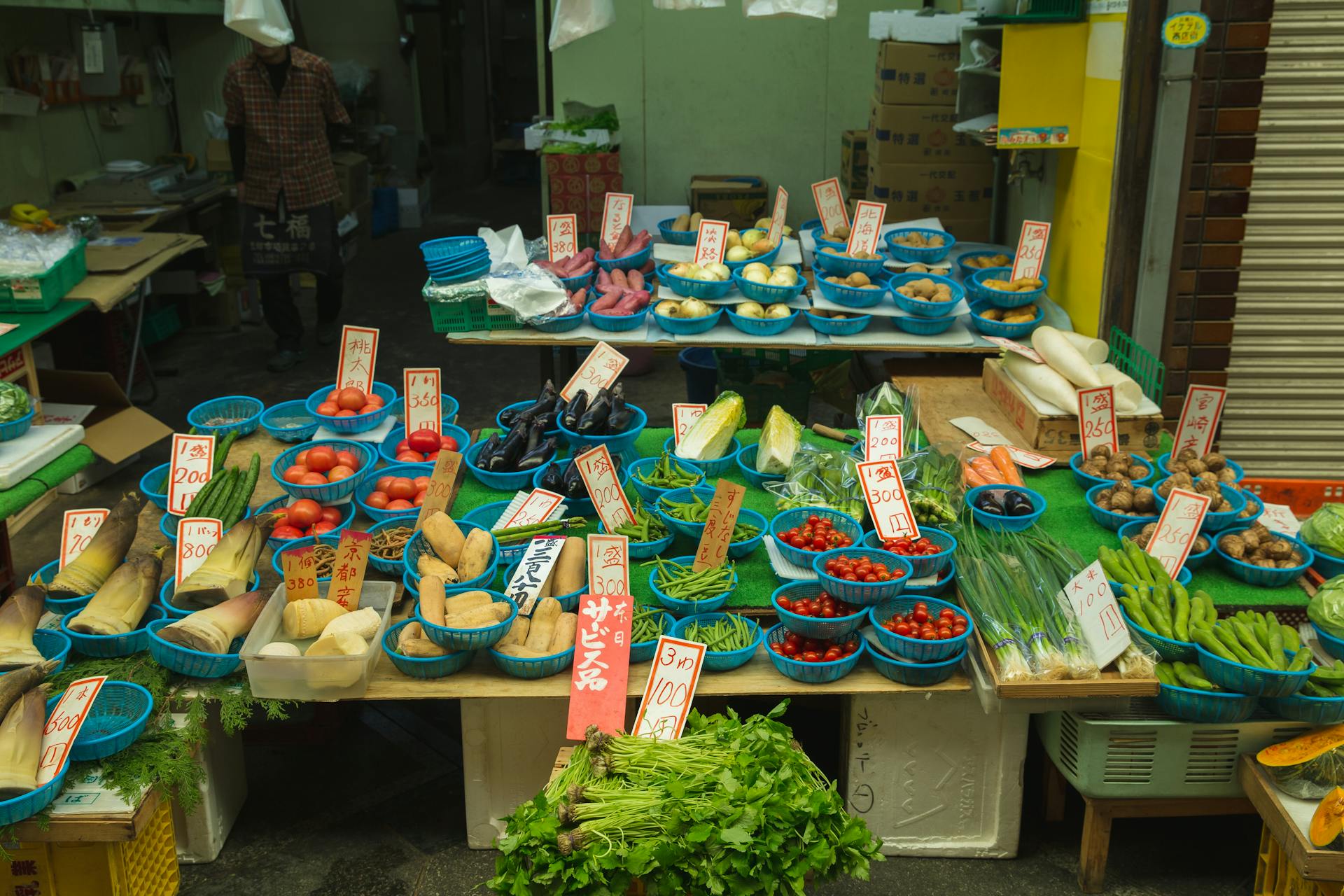 Japanese trader selling fresh tomatoes and other fresh vegetables to customers in the street market