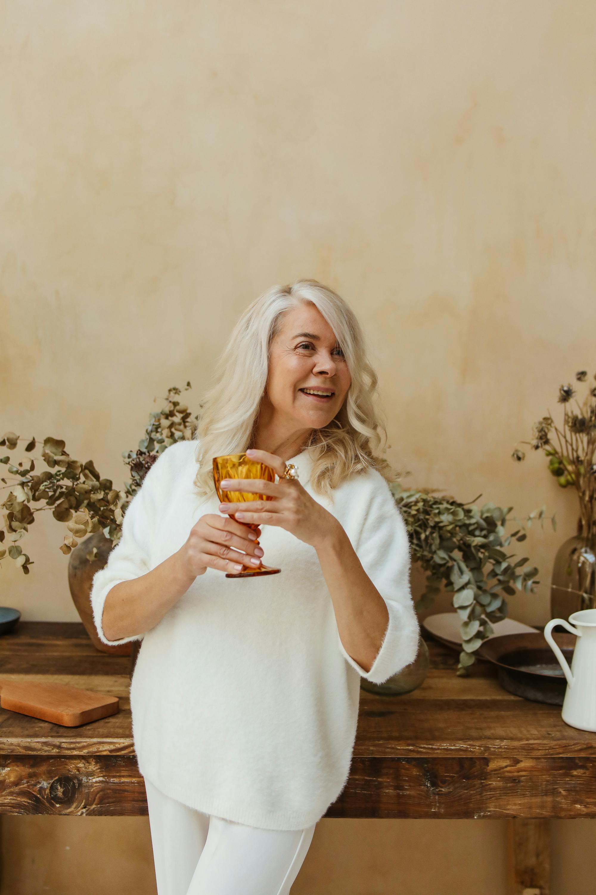 a happy elderly woman holding a goblet