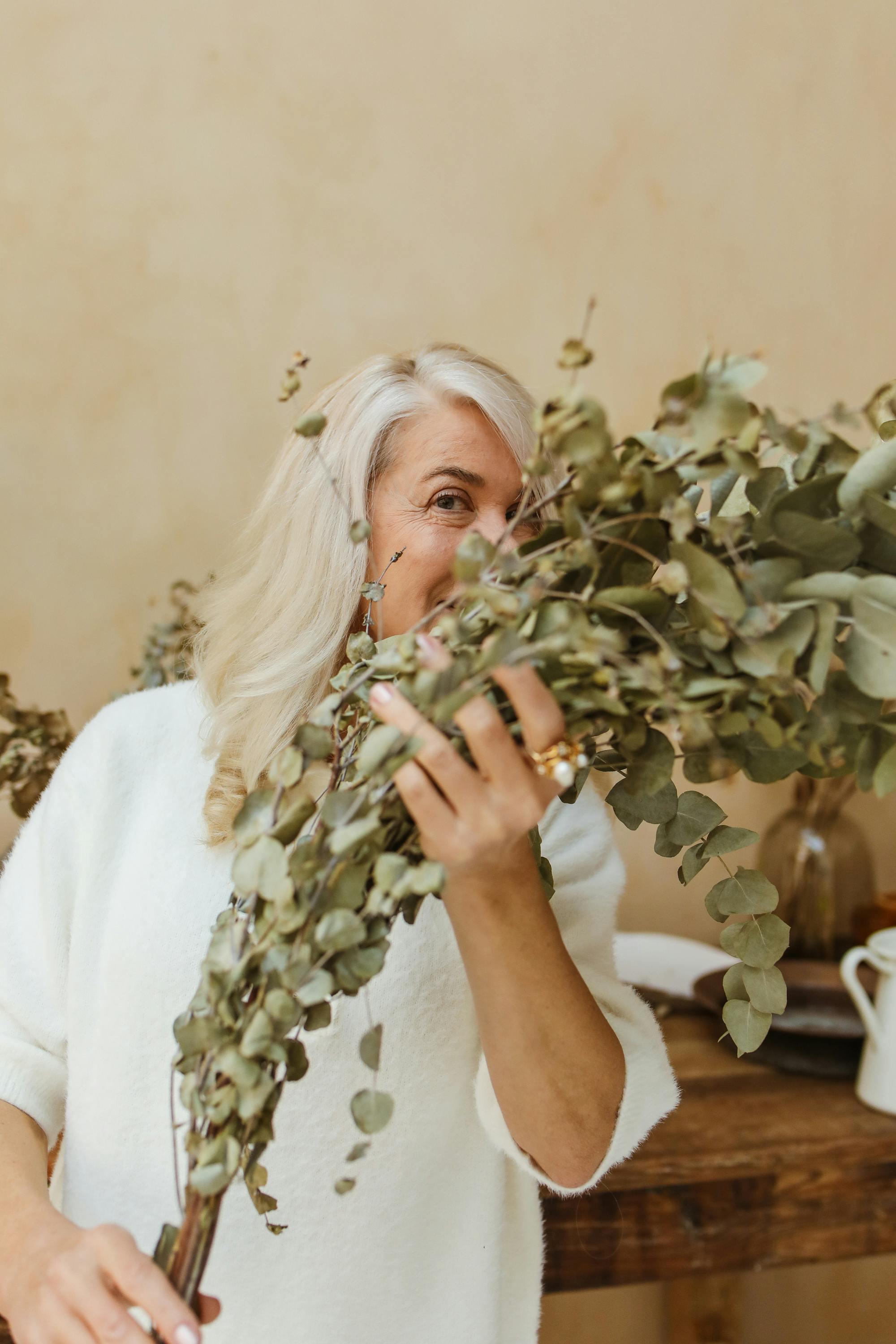 a woman holding eucalyptus branches