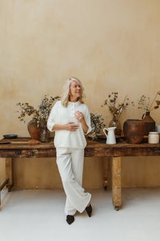 老妇人兴高采烈地站在室内，乡村装饰映衬着她，散发着温暖和满足