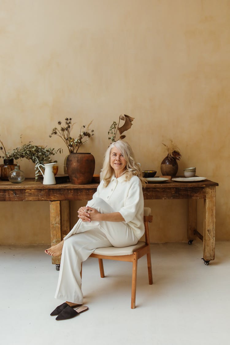 A Happy Elderly Woman Sitting In A Chair