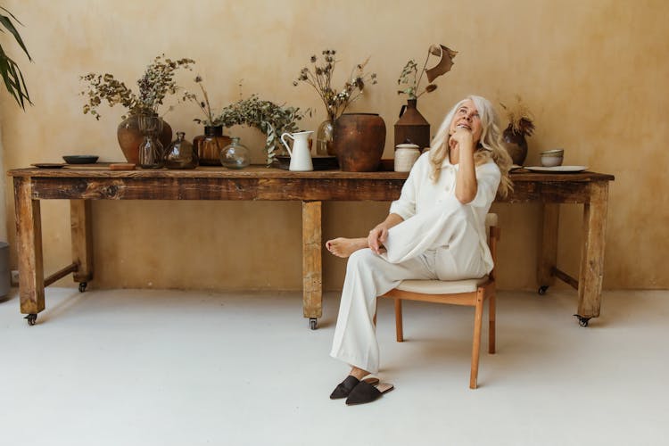 A Happy Elderly Woman Sitting In A Chair