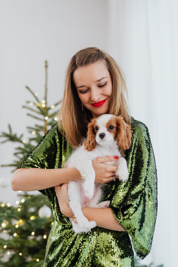 Smiling Woman In Green Dress Holding Her Cute Puppy