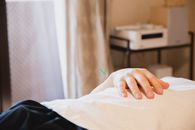 在沙龙治疗期间，一位匿名男性客户手持针头躺在沙发上