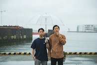 Young ethnic men with umbrella