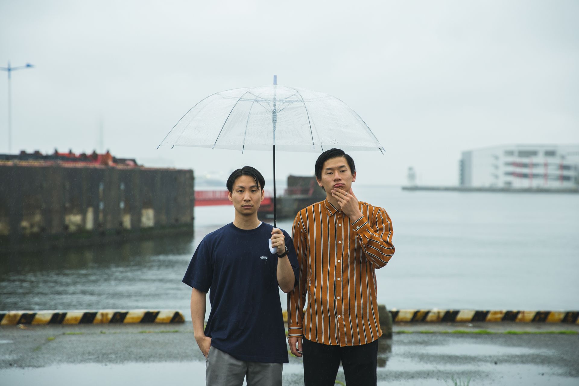 Young ethnic men with umbrella