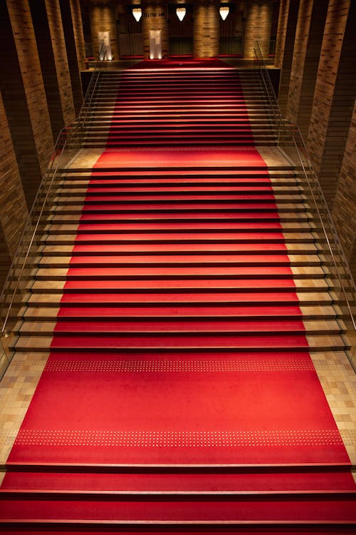 Free From above of majestic rich interior of old building hall with red carpet on staircase Stock Photo
