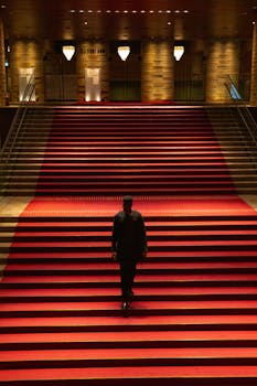 宽敞的大厅铺着红地毯，一个黑影正悄然走上楼梯