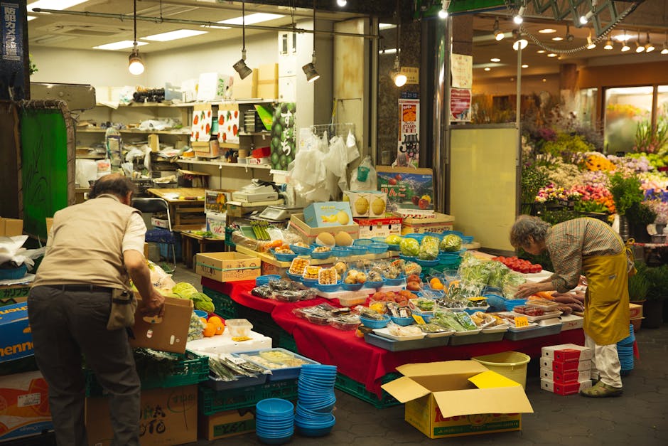 Arranged colorful containers with healthy vegetables and juicy fruits on lightened stall in market