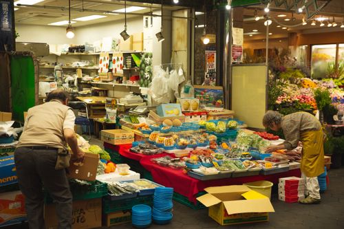 Free Arranged colorful containers with healthy vegetables and juicy fruits on lightened stall in market Stock Photo