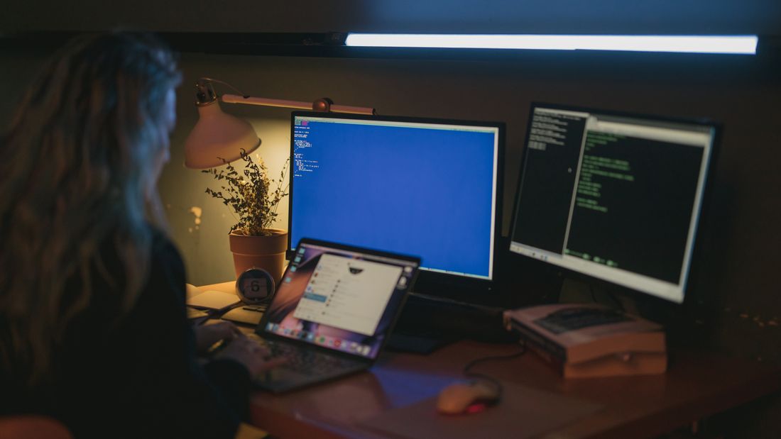 Persona revisando el trabajo de un sistema digital en dos pantallas de oficina
