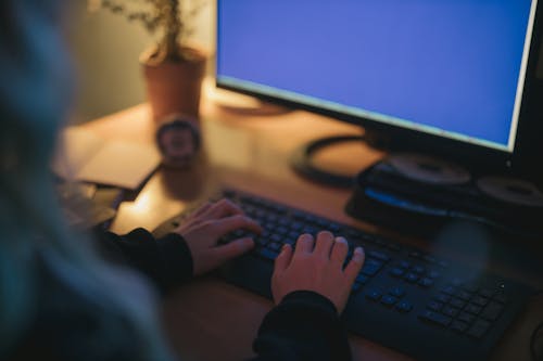 Person in Black Blazer Typing on Keyboard