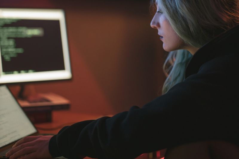 Developer working on a laptop in a dark coding workspace