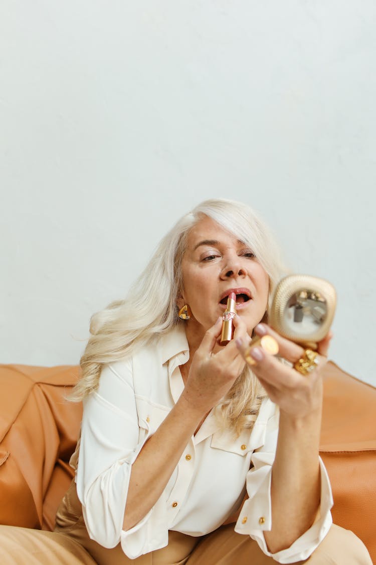 Elderly Woman Putting On Lipstick