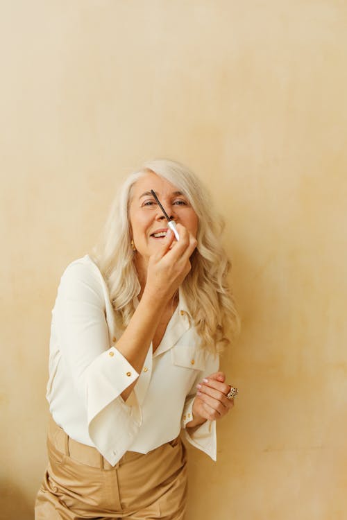 Kostnadsfri bild av äldre kvinna, ansiktsuttryck, beige bakgrund