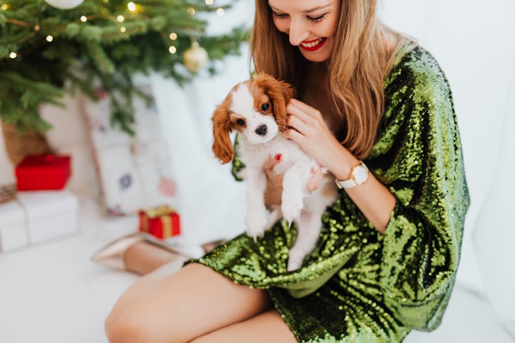 Shallow Focus Photo Of A Happy Woman Holding Her Puppy