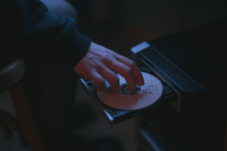 Person Putting A CD In A Computer