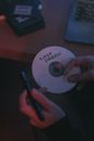 Close-Up Photo of Person Labeling a Compact Disc with a Marker