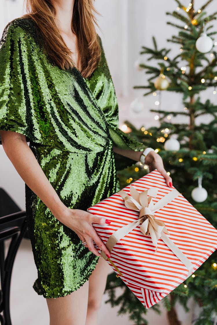 Woman In Green Glittery Dress Holding A Gift Box