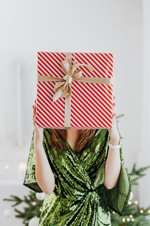 Free Woman in Green Glittery Dress Holding a Gift Box Stock Photo
