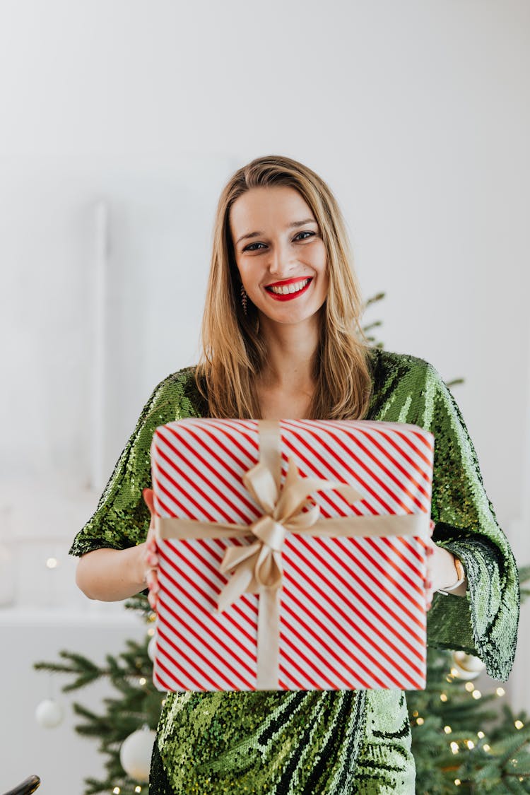 Pretty Woman In Green Dress Holding A Christmas Gift