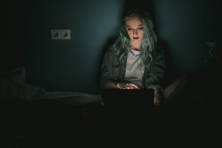 Woman Using A Laptop In The Dark