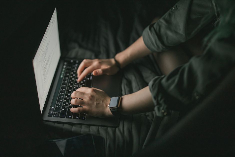 ExpressVPN Lightway vs NordVPN NordLynx: Speed and Security Compared Hands typing on a laptop in a dark setting, technology and focus concept.