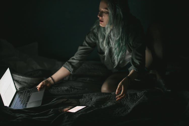 Woman Using Laptop In The Dark